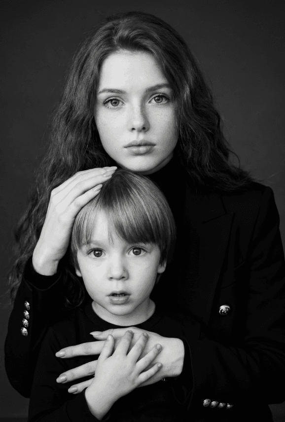 Чёрно-белый студийный портрет женщины, обнимающей маленького мальчика