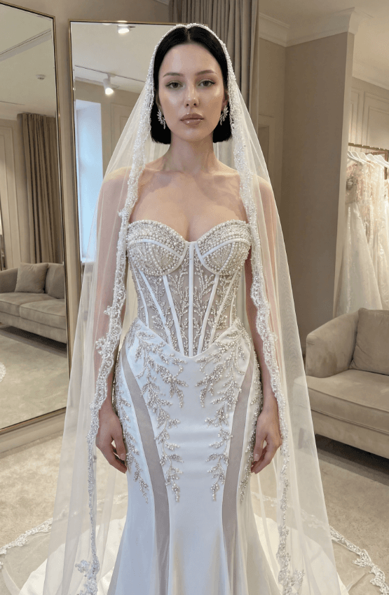 Невеста в жемчужном корсетном свадебном платье с кружевной фатой