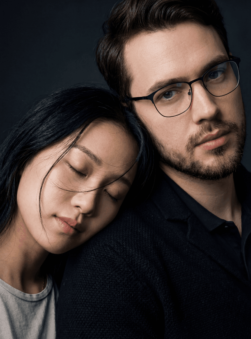 Женщина с закрытыми глазами на плече мужчины, студийный портрет.