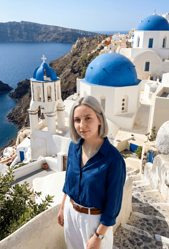 Женщина на ступенях у синекупольной церкви в Ойе, кальдера Санторини